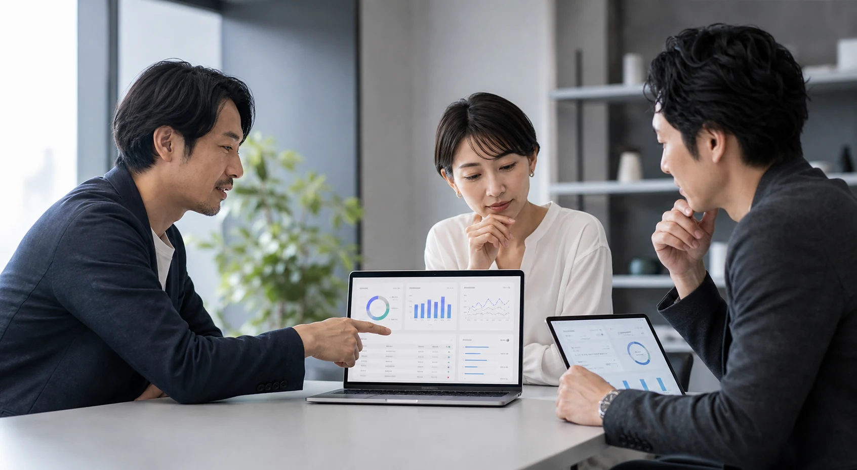 社内システムを見ながら打ち合わせるチーム